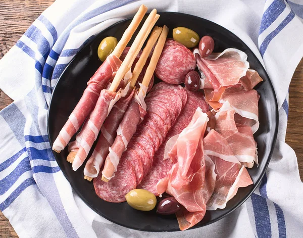 Prosciutto, salami, bread sticks and olives — Stock Photo, Image