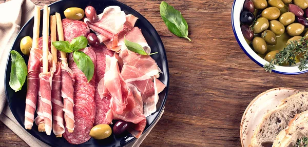 Ham, salami, brood sticks en olijven — Stockfoto