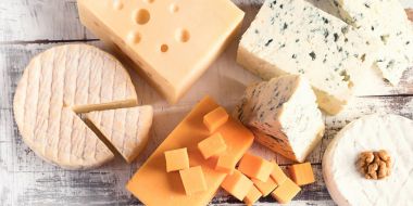 Rustik ahşap tahta üzerinde peynir çeşitleri.