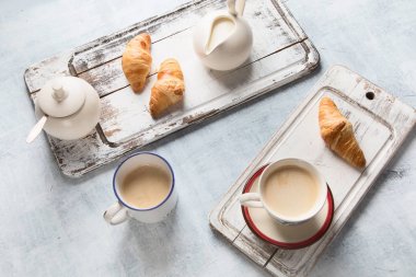 Fincan kahve ve kruvasan ile kahvaltı. Üstten Görünüm