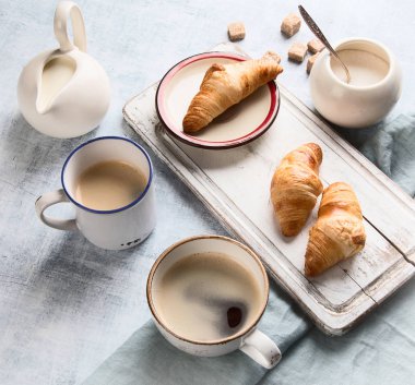 Fincan kahve ve kruvasan ile kahvaltı. Üstten Görünüm