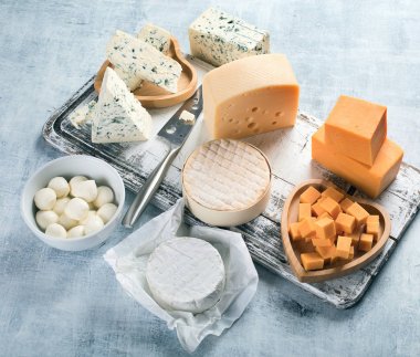 Rustik ahşap tahta üzerinde peynir çeşitleri.