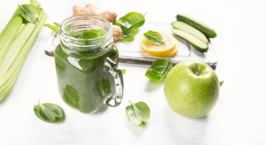 Cam malzemelerle ahşap masa üzerinde sağlıklı yeşil smoothie
