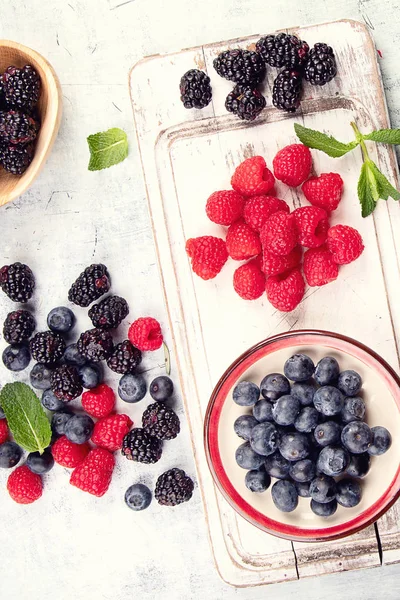 Different kinds of fresh berries mix on wooden surface