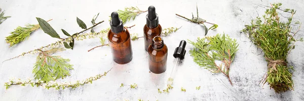 Bottles with organic essential aroma oil for aromatherapy with herbs