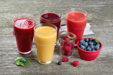 Ahşap arka planda farklı türde meyve püresi. Sağlıklı temiz ve detoks diyet yeme konsepti.