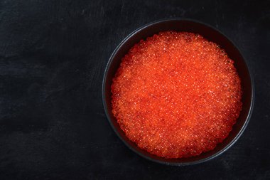 Somon yumurtası. Siyah arka planda kırmızı havyar. Kopyalama alanı olan üst görünüm