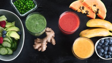 Siyah arka planda farklı türde smoothie 'ler. Sağlıklı temizlik ve detoks diyeti kavramı. Üst görünüm