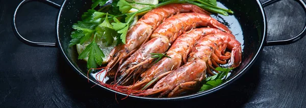 Roasted  prawn  shrimps on black background.  Panorama, banner