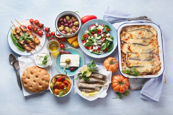 Greek food. Moussaka, meze, souvlaki, fish, pita, greek salad, tzatziki,  olives and vegetables. Traditional different types of greek dishes. Top view
