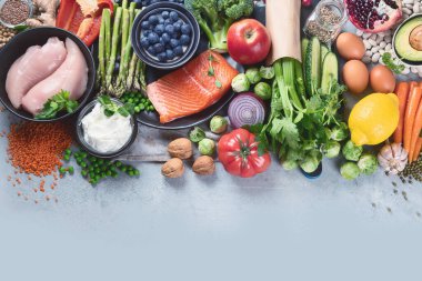 Gri arka planda sağlıklı yiyecek seçimi. Detoks ve temiz diyet konsepti. Yüksek miktarda vitamin, mineral ve antioksidan içeren yiyecekler. Yaş karşıtı yiyecekler. Kopyalama alanı olan üst görünüm