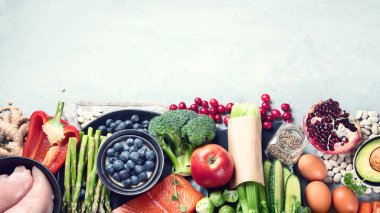 Gri arka planda sağlıklı yiyecek seçimi. Detoks ve temiz diyet konsepti. Yüksek miktarda vitamin, mineral ve antioksidan içeren yiyecekler. Yaş karşıtı yiyecekler. Kopyalama alanı olan üst görünüm