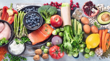 Gri arka planda sağlıklı yiyecek seçimi. Detoks ve temiz diyet konsepti. Yüksek miktarda vitamin, mineral ve antioksidan içeren yiyecekler. Yaş karşıtı yiyecekler. Üst görünüm 