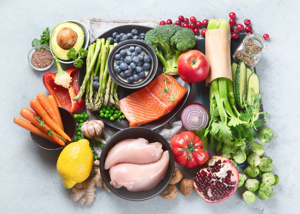 Healthy food selection on gray background. Detox and clean diet concept. Foods high in vitamins, minerals and antioxidants. Anti age foods. Top view, flat lay