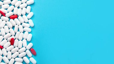 Mavi arka planda bir sürü hap. Kopyalama alanı olan üst görünüm