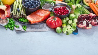 Gri arka planda sağlıklı yiyecek seçimi. Detoks ve temiz diyet konsepti. Yüksek miktarda vitamin, mineral ve antioksidan içeren yiyecekler. Yaş karşıtı yiyecekler. Kopyalama alanı olan resim