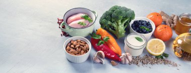 Bağışıklık sistemi sağlıklı gıda seçimini arttırıyor. Gri arka planda yüksek miktarda antioksidan, mineral ve vitamin içeren yiyecekler. Panorama, kopyalama alanı olan pankart