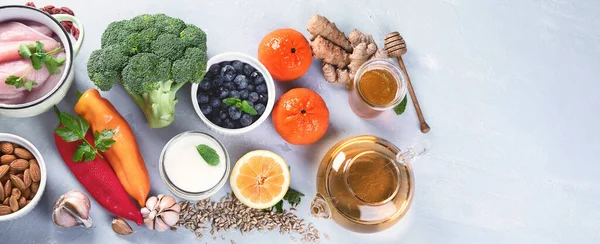 Immune boosting health food selection. Foods high in antioxidants, minerals and vitamins on grey background. Top view with copy space. Panorama, banner