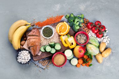 Gri arka planda yüksek karbonhidrat içeren yiyecekler. Vegan gıdaları yüksek miktarda diyet lifleri, antioksidanlar, vitaminler ve mineraller. Üst manzara, düz uzanma