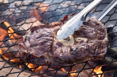 Kömürün üstünde ızgara ızgarada biftek bacakları. Yukarıdan görüntüle