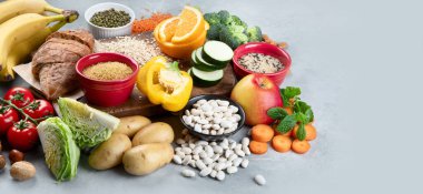 Gri arka planda yüksek karbonhidrat içeren yiyecekler. Vegan gıdaları yüksek miktarda diyet lifleri, antioksidanlar, vitaminler ve mineraller. Panorama, kopyalama alanı olan pankart