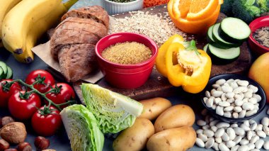Gri arka planda yüksek karbonhidrat içeren yiyecekler. Vegan gıdaları yüksek besin lifleri, antioksidanlar, vitaminler ve mineraller. 