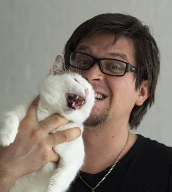 genç adam kedi tutar 