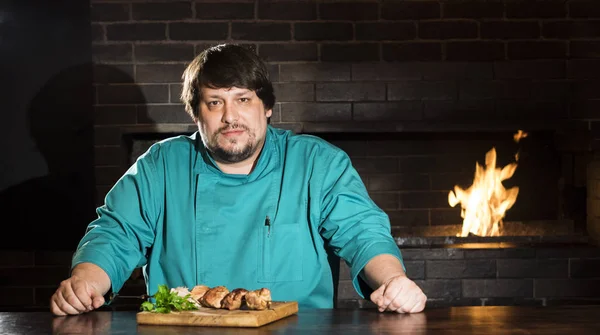 Chef with meat cooked on a skewer — Stock Photo, Image