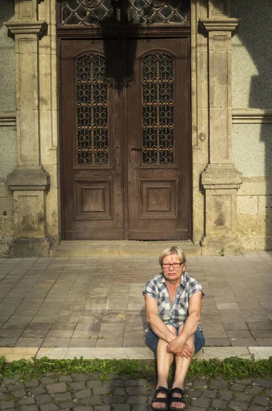 Женщина в клетчатой рубашке сидит на лестнице — стоковое фото