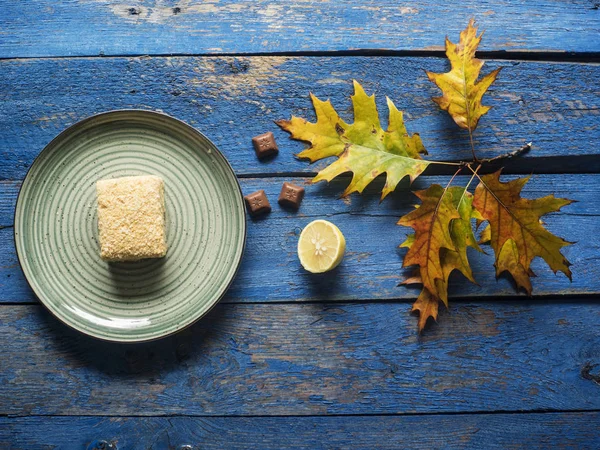 Teller Mit Kuchen Zitrone Und Ahornblatt Auf Blau Bemaltem Dielentisch — Stockfoto