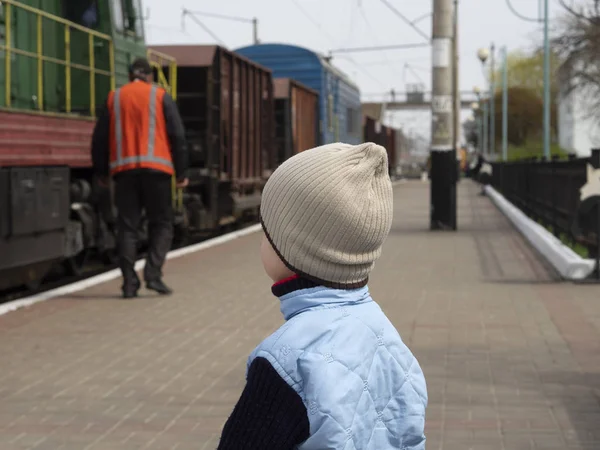 Хлопчик дивиться на залізничника — стокове фото