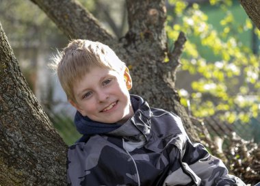 ağaç üzerinde oturan çocuk