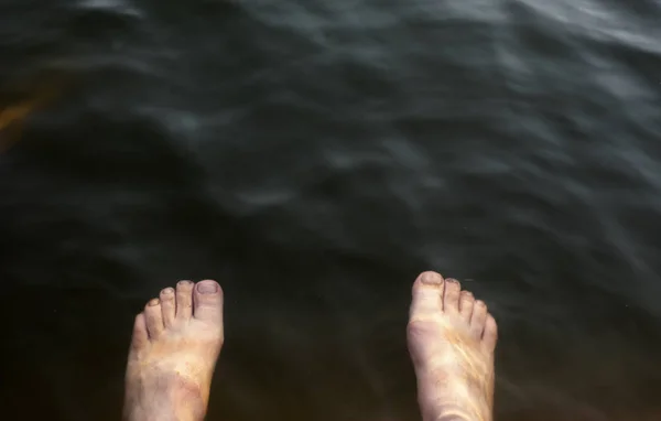 Feet of a man in the water — Stock Photo, Image