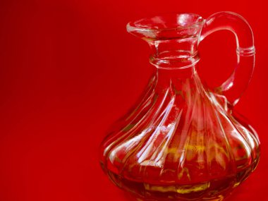 Kırmızı arka planda bir şişe zeytinyağı