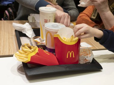 McDonalds 'da hamburger ve patates kızartması yiyen insanlar.