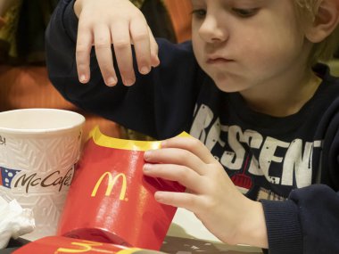 McDonalds 'da patates kızartması yiyen küçük çocuk.