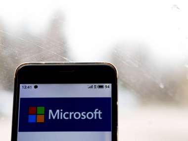 Bu resimde Microsoft logosu akıllı bir telefondan gösteriliyor.
