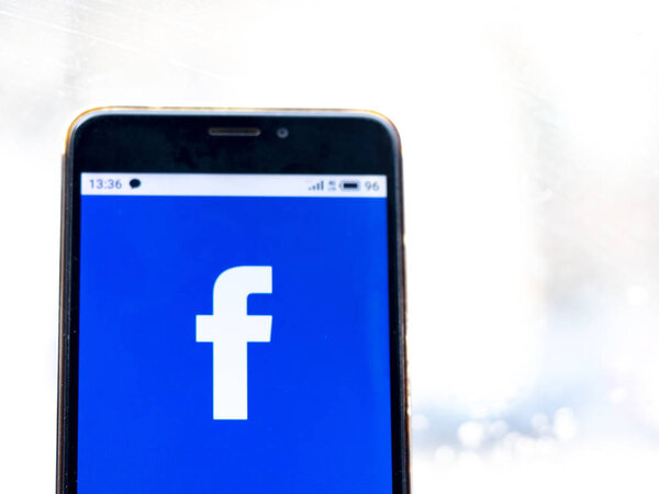 In this photo illustration the Facebook logo is seen displayed on a smartphone