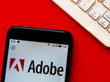 Bu fotoğraf illüstrasyonunda Adobe Inc. logosu bir akıllı telefonda görüntülenir