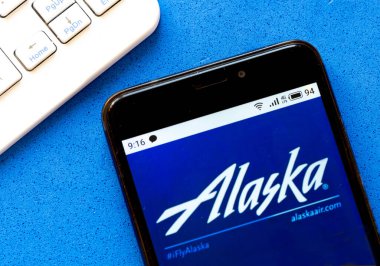 Bu resimde Alaska Grubu logosu akıllı bir telefondan gösteriliyor.
