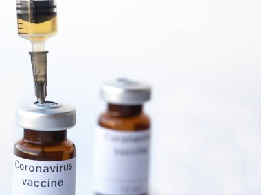 Dünya endişeyle koronavirüse karşı bir aşı bekliyor. Fotoğrafta Coronavirus aşısı ve şırınga etiketli iki şişe var..