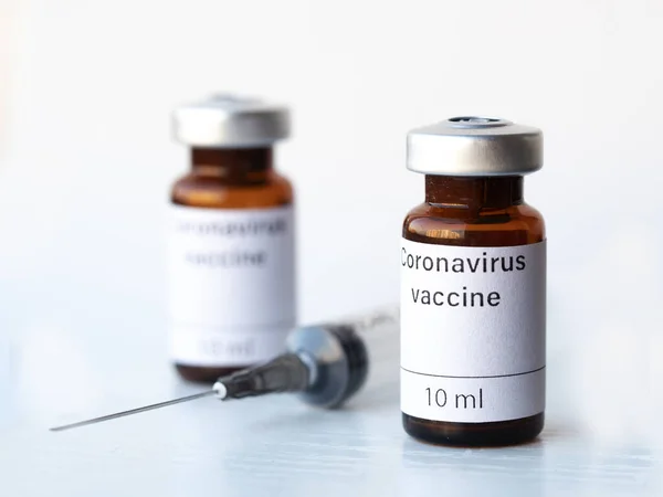全世界都在焦急地等待着一种针对头孢病毒的疫苗 图上显示了两个标有考罗那韦疫苗和注射器的瓶子 图库照片