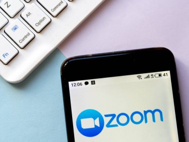Bu resimde Zoom logosu bir akıllı telefonda görüntülenir