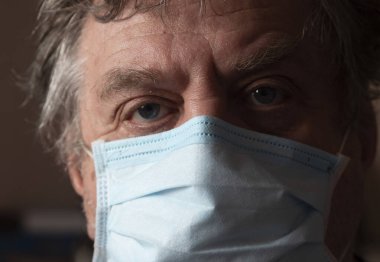 Koruyucu maskeli emekli adam. Milyonlarca Ukraynalı çocuk ve emekli bir aydır karantina altında..