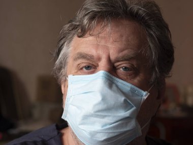 Koruyucu maskeli emekli adam. Milyonlarca Ukraynalı çocuk ve emekli bir aydır karantina altında..