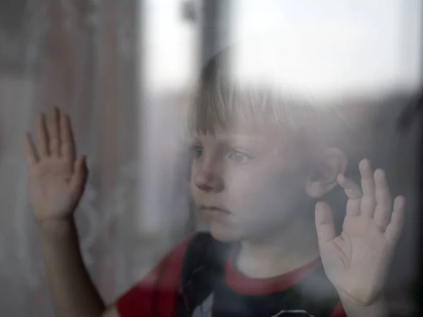 Der Junge Blickt Durch Ein Geschlossenes Fenster Auf Die Straße — Stockfoto