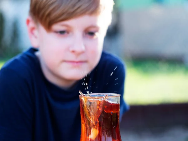Kafkasyalı Çocuk Düşen Bir Şeker Parçasından Bir Fincanda Çay Sıçramasını — Stok fotoğraf