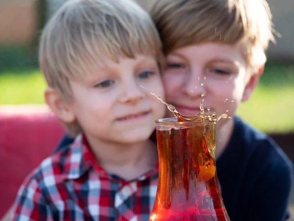 Two Caucasian Boys Watches Splash Tea Cup Falling Piece Sugar — Stock Photo, Image
