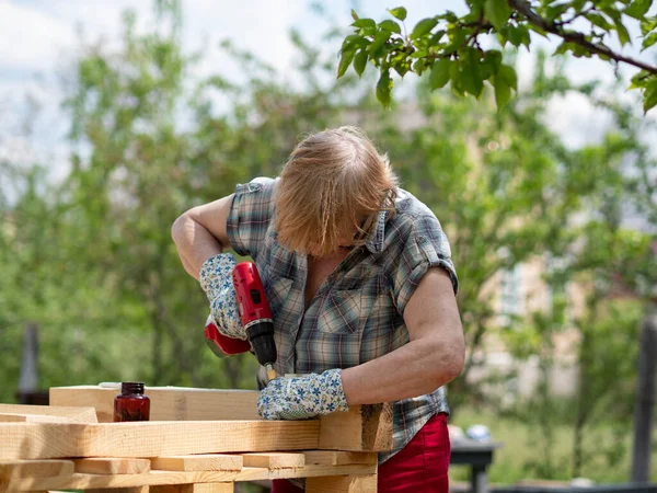 Starsza Kaukaska Kobieta Montuje Drewnianą Ramę Budynku Pomocą Metalowych Elementów — Zdjęcie stockowe