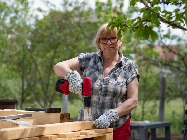 Senior Caucasian Woman Assembles Wooden Frame Building Using Metal Fasteners — Stock Photo, Image